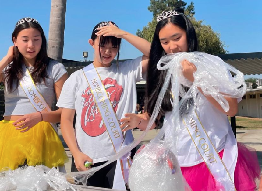 Homecoming princess senior Anabelle Kim (right) unravels the Saran Wrap ball as part of the court game on Tuesday, Oct. 1, during break in the quad. Kim is also wearing a tutu as part of the homecoming spirit week.